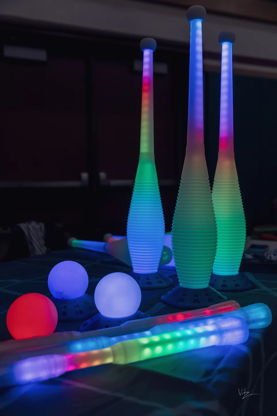 some brightly colored juggling props glowing in the dark